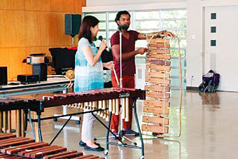 Man and a female student explaining ethnic instruments at a workshop of the Graduate School of Cultural Arts Studies