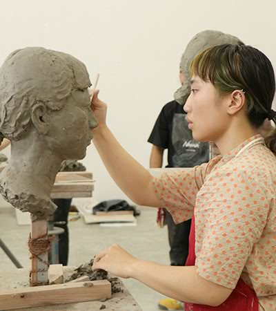 ［写真］塑像制作する学生