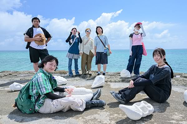 ［写真］ビーチでポーズを決める学生たち